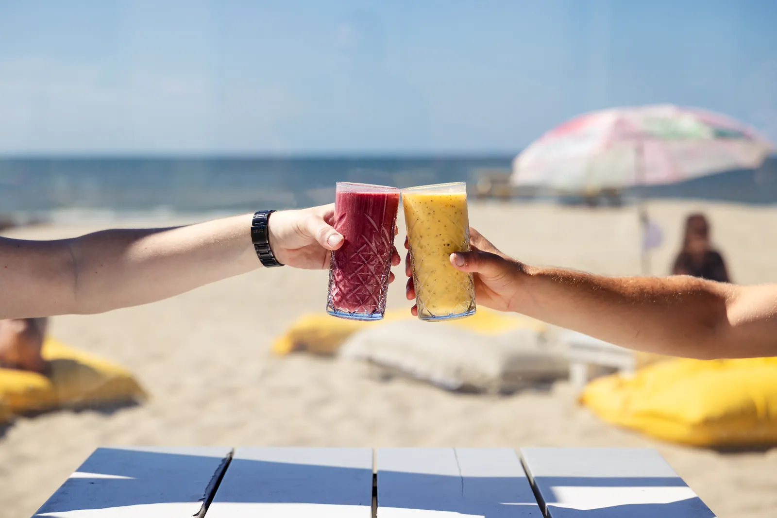 Zwei Smoothies stoßen am Strand an